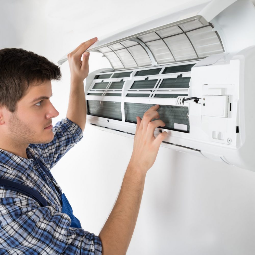 mantenimiento-aire-acondicionado técnico manejando un aparato de aire acondicionado